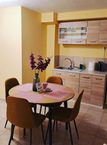 a kitchen with a table and chairs with flowers on it at Zenia Home 1 Στην καρδιά της Πάτρας in Patra