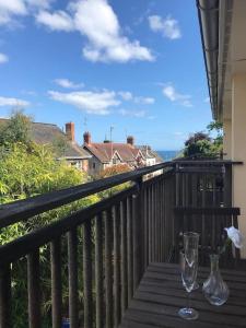 a wooden table with a wine glass on a balcony at 2 Dorset Mews in Lyme Regis