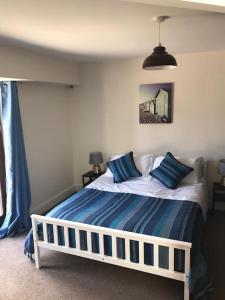 a bedroom with a bed with blue pillows on it at 2 Dorset Mews in Lyme Regis