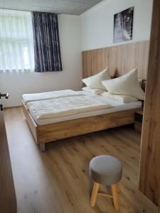 a bedroom with a large bed and a chair at Lucashof Millstättersee in Millstatt