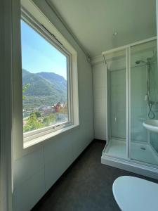 a bathroom with a window and a shower and a sink at Odda City Apartments in Odda