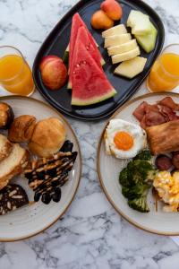 two plates of breakfast food on a table at Paros Agnanti Resort & Spa in Parikia