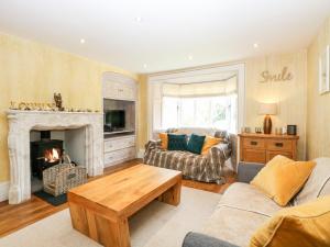 a living room with a couch and a fireplace at The Farmhouse in North Walsham