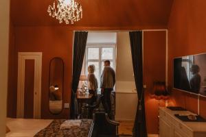 two people standing in a bedroom looking out the window at Hotel Slottsvillan in Jönköping