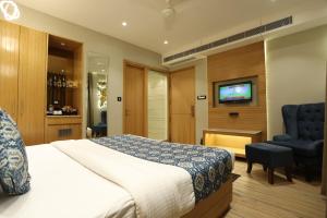 Habitación de hotel con cama y TV en JRD Luxury, en Nueva Delhi