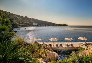 a bridge with umbrellas over a body of water at Boutique & Design Hotel Navis - Small Luxury Hotels of the World in Opatija