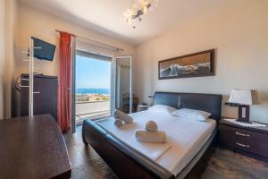 een slaapkamer met een bed en uitzicht op de oceaan bij Villa MANŪ, a fair living in Chersonissos