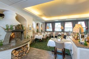 un restaurante con chimenea, mesas y sillas en Genuss - und Vitalhotel Moisl, en Abtenau