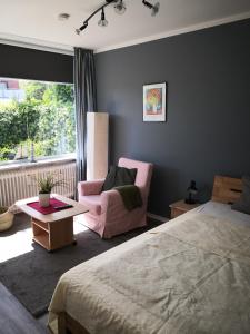 een slaapkamer met een bed, een stoel en een raam bij Appartementhaus Martel - Adults Only in Travemünde