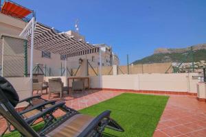 a patio with a fence and a table and grass at RIURAU HOME ático dúplex en Calpe in Calpe
