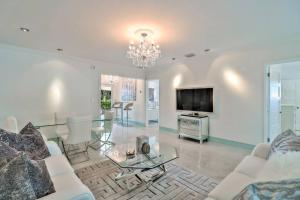 sala de estar con sofá, mesa y TV en Stunning 2bdr2bath Steps To The Beach, en Fort Lauderdale