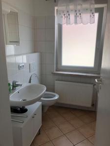 a bathroom with a sink and a toilet and a window at Family House Bibertal in Bibertal 