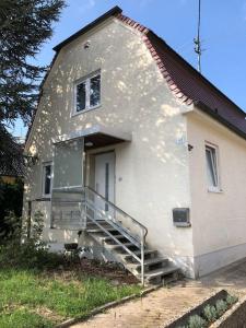 uma pequena casa branca com uma porta e escadas em Family House Bibertal em Bibertal 