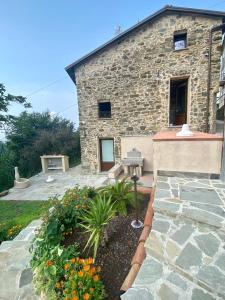 a stone house with a garden in front of it at Casa Dell'Angelo Cherubino Monolocale in Castelnuovo Magra