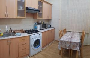Central Baku Luxury Boulivard Apartment في باكو: مطبخ مع غسالة ملابس بجانب طاولة
