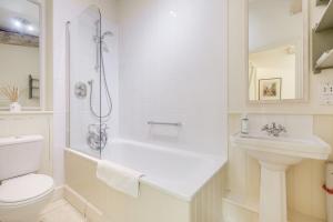 a white bathroom with a toilet and a sink at Giddy Cottage in Eastdean +20 photos