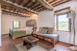 a bedroom with a bed and a couch and a table at Antica Porta di Sovana in Pitigliano