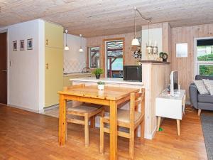 Nøragerにある6 person holiday home in Alling broのキッチン、リビングルーム(木製テーブル、椅子付)