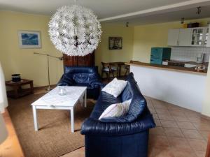 a living room with a blue leather couch and a table at Chalet Forsthof Everstorf - kleine Wohnung in Grevesmühlen
