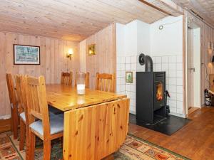 a dining room with a wooden table and a wood stove at 6 person holiday home in Alling bro in Nørager