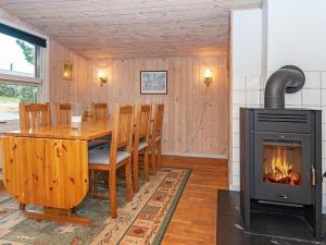 a dining room with a table and a fireplace at 6 person holiday home in Alling bro in Nørager
