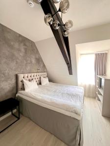 sypialnia z dużym łóżkiem z białą pościelą w obiekcie Rezidence Wannas Self Check in w mieście Sigulda