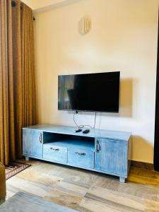a blue entertainment center with a flat screen tv on top at Vista Apartment Mariners Blue in Nuwara Eliya