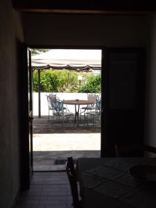 una puerta abierta a un patio con mesa y sillas en Case Vacanze Villa Lory, en Malfa