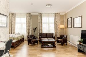 a living room with chairs and a couch and a tv at Sunlight Hotel Conference & Spa in Nyköping