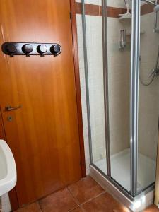 una doccia con una porta in vetro in un bagno di Il Ricordo appartamento a Champoluc