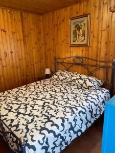 a bedroom with a bed with a black and white comforter at Il Ricordo appartamento in Champoluc