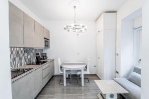 a kitchen with a white table and a white chair at Kenti Residence in Ljubljana