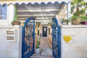 a blue gate leading to a house with plants at Mike's House Jerusalem in Jerusalem