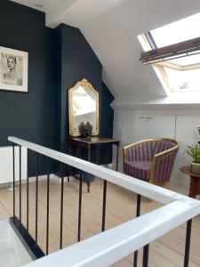 a staircase with a mirror and a chair at Charming rooms in green area in Sint-Martens-Latem
