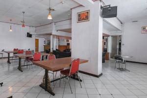 un grupo de mesas y sillas en una habitación en RedDoorz @ Achino Hotel Bandung, en Bandung
