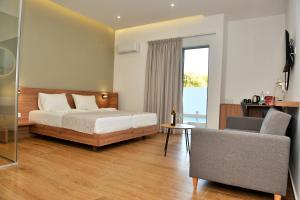 een slaapkamer met een bed, een stoel en een raam bij Katia Hotel in Ixia