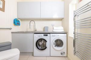 a kitchen with a washing machine and a sink at Cauldhame House in Dunblane