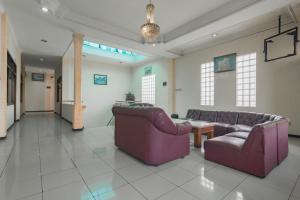 Sala de estar con 2 sofás y mesa en RedDoorz @ Achino Hotel Bandung, en Bandung