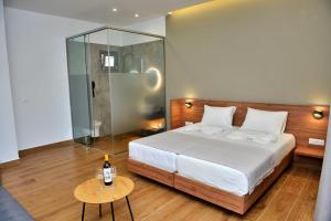 a bedroom with a bed and a glass shower at Katia Hotel in Ixia