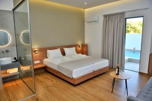 a bedroom with a large bed and a glass shower at Katia Hotel in Ixia