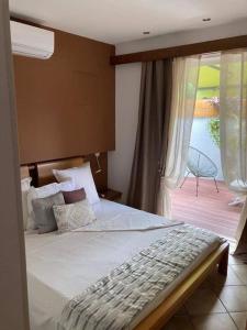 a bedroom with a large bed and a balcony at Chez Arlette in Saint-Louis