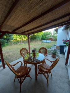 a table and four chairs on a patio at Tisza-tavi Kiserdő Vendégház in Tiszaderzs