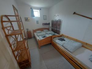 Habitación pequeña con 2 camas y escalera. en Tisza-tavi Kiserdő Vendégház, en Tiszaderzs