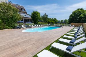 a large swimming pool with lounge chairs and a swimming pool at Les Jardins de Deauville in Saint-Martin-aux-Chartrains
