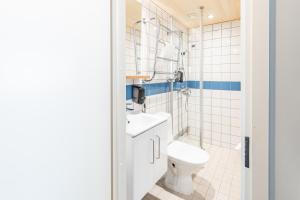 a white bathroom with a toilet and a sink at Sporttihotelli Pihkala in Vierumäki