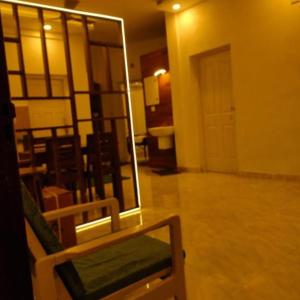 a room with a mirror and a chair in a room at Royal Square Service Apartment in Thrissur Town in Trichūr