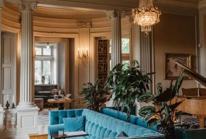 a living room with a blue couch and a chandelier at Hotel Slottsvillan in Huskvarna