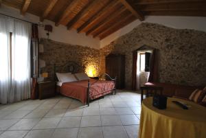 ein Schlafzimmer mit einem Bett und einem Tisch in einem Zimmer in der Unterkunft Agriturismo Masseria Baronali in Borgagne