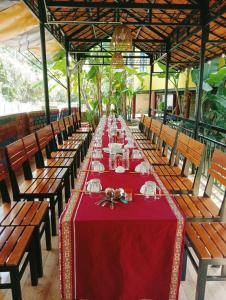 Kon Tum的住宿－Homestay Nang Nghieng，一张长桌子,上面有红色的桌布和椅子