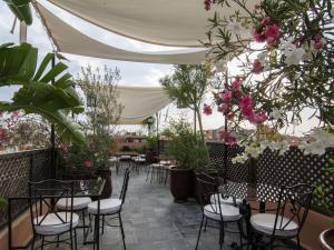 patio ze stołami, krzesłami i kwiatami w obiekcie Riad Le Bel Oranger w Marakeszu